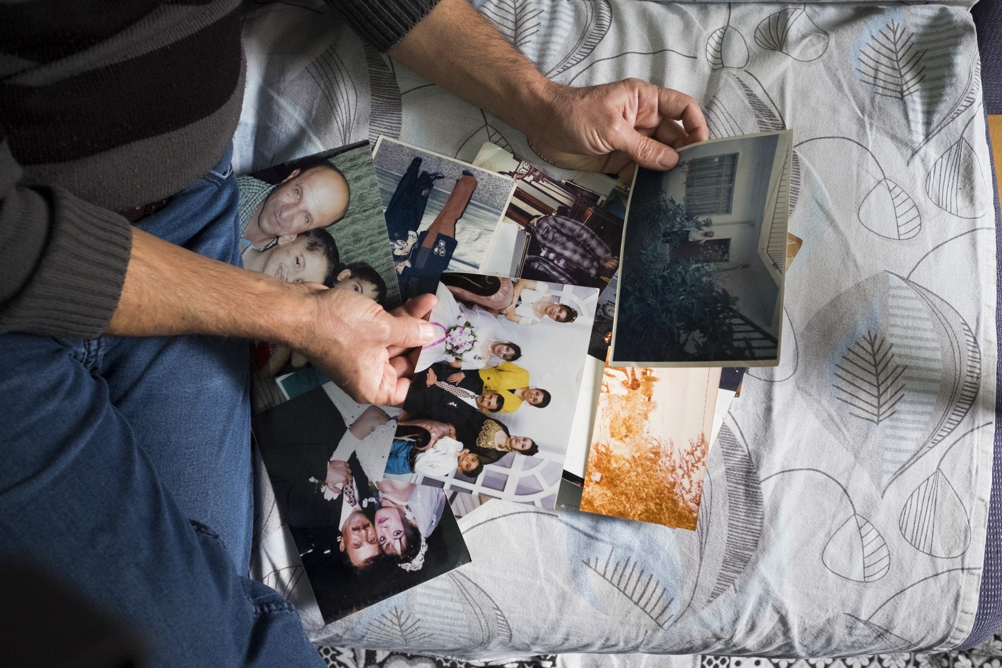 Sami Dankha, 51, looks at old family photographs Nov. 21; he brought them from Iraq to Istanbul, where he is now a refugee. He lives In Istanbul with his wife and five children; his brothers live in New Zealand, Australia and the Netherlands. (Credit: CNS photo/Oscar Durand.) 