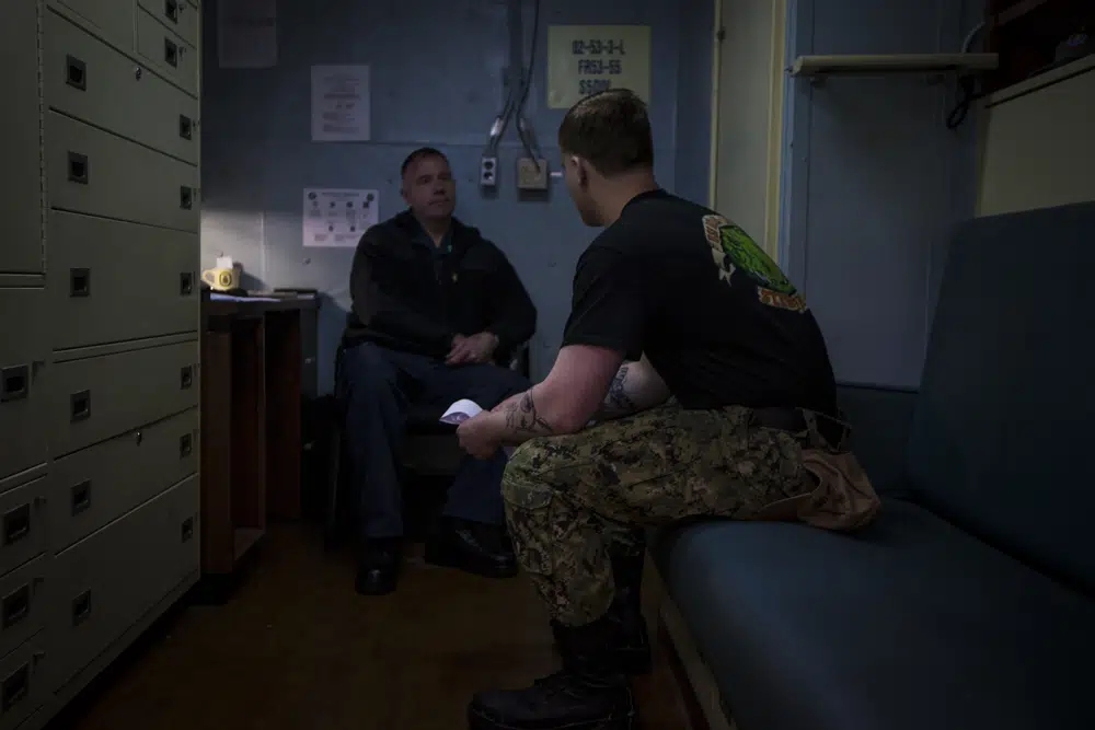 Navy Chaplain Lt. Cmdr. Ben Garrett counsels a sailor in his quarters on the USS Bataan on Monday, March 20, 2023 at Norfolk Naval Station in Norfolk, Va. One of the chaplains' roles aboard the ship is help sailors deal with stress Navy life brings. (Credit: John C. Clark/AP.)