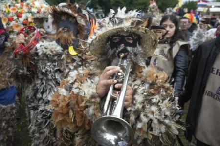 A parishioner dressed in feather costume plays a trumpet during a procession celebrating Saint Francisco Solano, in Emboscada, Paraguay, Thursday, July 24, 2025. Hundreds of Catholic parishioners in Paraguay don bird-like costumes and parade down the streets to honor the 16th century saint said to possess miraculous powers. (Credit: Jorge Saenz/AP.)