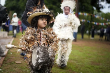 A child dressed in a feather costume plays a drum after attending a Mass celebrating Saint Francisco Solano, in Emboscada, Paraguay, Thursday, July 24, 2025. Hundreds of Catholic parishioners in Paraguay don bird-like costumes and parade down the streets to honor the 16th century saint said to possess miraculous powers. (Credit: Jorge Saenz/AP.)