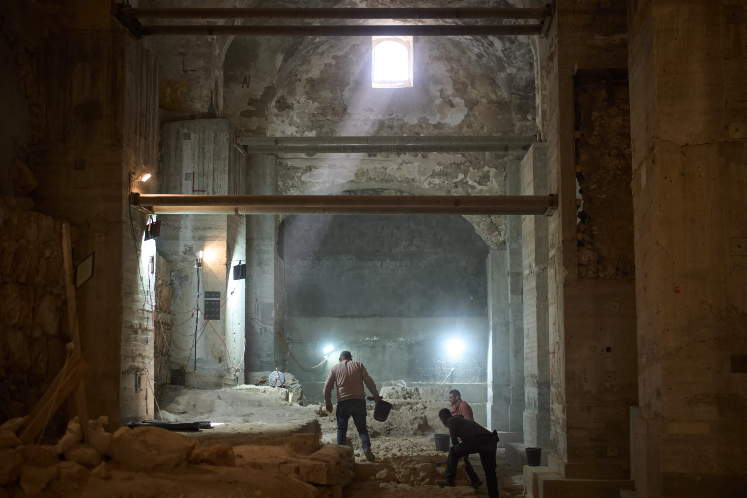 Workers from the Israel Antiquities Authority clean a section of an excavation site where, according to the institution, a city wall from the Hasmonean period, dating to the late 2nd century BCE, was uncovered under the Tower of David Citadel Museum, in the Old City of Jerusalem, Monday, Dec. 8, 2025. (Credit: Leo Correa/AP.)