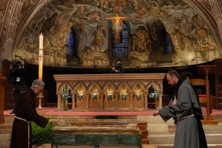 Friars pray before the remains of Francis of Assisi inside the Basilica of St. Francis of Assisi in Assisi, Italy, Saturday, Feb. 21, 2026, on the eve of a public exposition beginning Feb. 22 to mark the 800th anniversary of his death in 1226. (Credit: Gregorio Borgia/AP.)