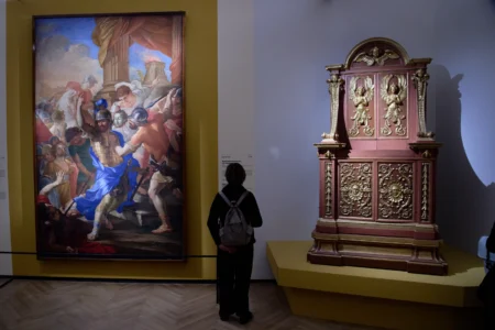 Journalists attend the press preview of the exhibition "Bernini and the Barberini" at Palazzo Barberini in Rome on Feb. 11, 2026, with the oil on canvas Martyrdom of St. Maurice (1640), left, by Carlo Pellegrini and Gian Lorenzo Bernini, and the model for the bronze casing of the Throne of St. Peter (1636) by Giovan Battista Soria on display. (Credit: Domenico Stinellis/AP.)