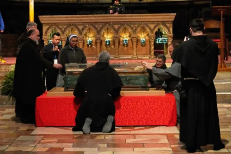 Friars and a nun pray before the remains of Francis of Assisi inside the Basilica of St. Francis of Assisi in Assisi, Italy, Saturday, Feb. 21, 2026, on the eve of a public exposition beginning Feb. 22 to mark the 800th anniversary of his death in 1226. (Credit: Gregorio Borgia/AP.)