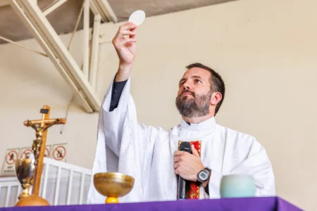 Father Brian Strassburger elevates the host at the altar during Mass at Casa del Migrante on Thursday, March 19, 2026, in Reynosa, Mexico. (Credit: Michael Gonzalez/AP.)