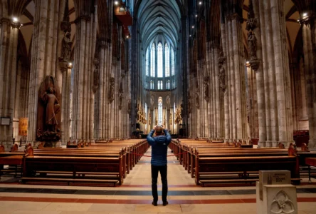 A tourist takes a picture inside the Cologne Cathedral in Cologne, Germany, Wednesday, Nov. 30, 2022. (Credit: Michael Probst/AP.)