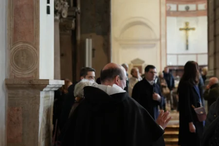 A friar of the Dominican community speaks with visitors in the Basilica of Santa Maria delle Grazie, best known as the home of Leonardo da Vinci's "The Last Supper," in Milan, Italy, Sunday, Feb. 15, 2026. (Credit: María Teresa Hernández/AP.)