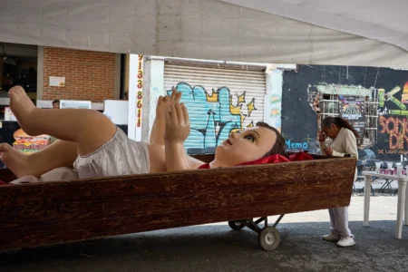 A parishioner crosses herself in front of a giant Baby Jesus in Mexico City, Tuesday, March 10, 2026. (Credit: Ginnette Riquelme/AP.)