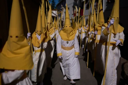 Penitents of the "Pollinita" brotherhodod take part in a Holy Week procession in Cabra, southern Spain, Sunday, March 29, 2026. (Credit: Manu Fernandez/AP.)