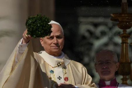 Pope Leo XIV sprinkles holy water with a bunch of hyssop sprigs as he presides over Easter Mass in St. Peter’s Square at the Vatican, Sunday, April 5, 2026. (Credit: Andrew Medichini/AP.)
