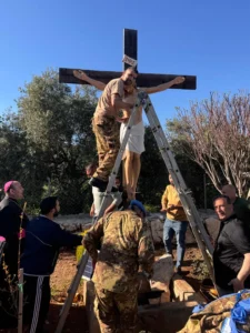 An Italian peacekeeper sets up a crucifix that was sent by Italy to replace one that was defaced last week by an Israeli soldier in the Christian village of Debel, south Lebanon, Wednesday, April 22, 2026. (Credit: Hossam Naddaf via AP.)