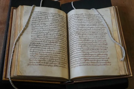 A rare, long-lost copy of Caedmon's Hymn — the first poem ever written down in Old English — is visible in the five lines above the final line of the left page from an 8th-century manuscript copy of the Venerable Bede's Ecclesiastical History of the English People, at Rome's National Library, Thursday, May 8, 2026. (Credit: Andrea Rosa/AP.)