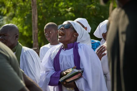 A member of a church choir sings during a funeralon the outskirts of Kisumu, Kenya, Friday, March 13, 2026. (Credit: Asa Wallin/AP.)