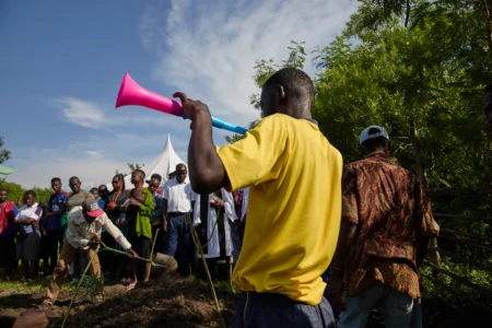 Family and friends shovel dirt onto the coffin of Tom Ochieng Mima on the outskirts of Kisumu, Kenya, Friday, March 13, 2026. (Credit: Asa Wallin/AP.)