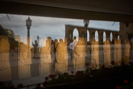 Tourists are reflected in the glass of a museum on the main square of the Monastery of Montserrat near Barcelona, Spain, Friday, June 5, 2026. (Credit: Emilio Morenatti/AP.)