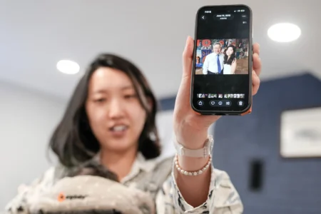 Grace Jin Drexel shows the old photos of her father after an interview with The Associated Press in Maryland, Wednesday, July 22, 2026 . (Credit: Mariam Zuhaib/AP.)