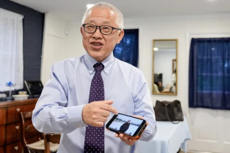 Chinese pastor Ezra Jin Mingri shows his photos after an interview with The Associated Press in Maryland, Wednesday, July 22, 2026 . (Credit: Mariam Zuhaib/AP.)