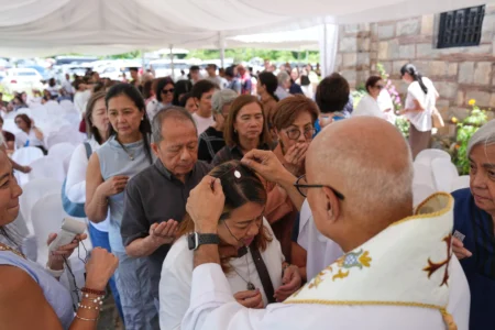 Catholic priest Father Dennis Paez places a scapular necklace on pilgrims during their visit at the Ephesus House, a replica of the House of the Virgin Mary in Ephesus, Turkey, at Alfonso town, Cavite province, Philippines on July 16, 2026. (Credit: Aaron Favila/AP.)