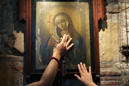 Catholics touch one of the images of Mary inside the Ephesus House, a replica of the House of the Virgin Mary in Ephesus, Turkey, at Alfonso town, Cavite province, Philippines on July 16, 2026. (Credit: Aaron Favila/AP.)