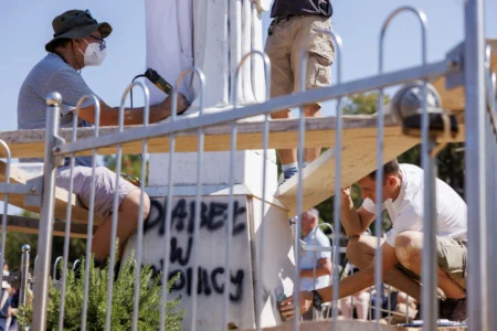 Volunteers clean the vandalized statue of the Virgin Mary, which has been covered with a white sheet, on Apparition Hill in Medjugorje, Bosnia, Tuesday, July 28, 2026. (Credit: AP Photo.)