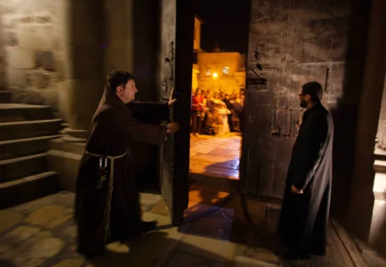 A priest closes the door to the Holy Sepulcher church for the night in Jerusalem on Thursday, May 17, 2012. (Credit: Dusan Vranic/AP.)