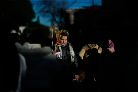 A religious souvenir vendor stands amid pilgrims waiting to enter the Church of San Cayetano during the annual pilgrimage honoring Saint Cajetan, the patron saint of work, in Buenos Aires, Argentina, Friday, Aug. 7, 2026. (Credit: Natacha Pisarenko/AP.)
