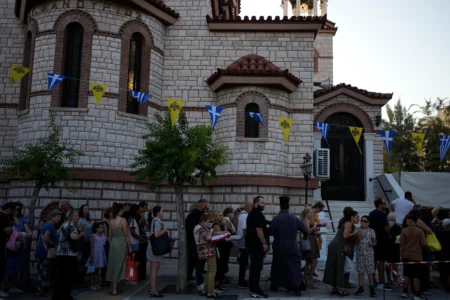 Pilgrims wait in line to have their Fanouropites, orange-flavored cakes, blessed at the Church of St. Fanourios in Athens, Wednesday, Aug. 26, 2026. (Credit: Thanassis Stavrakis/AP.)