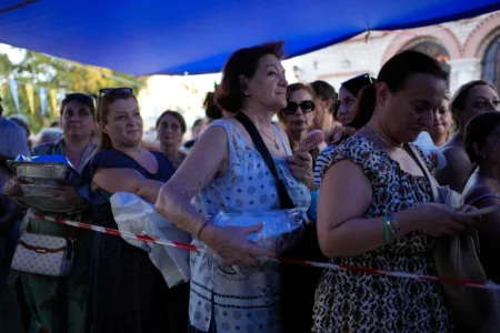 Pilgrims wait in line to have their Fanouropites, orange-flavored cakes, blessed at the Church of St. Fanourios in Athens, Wednesday, Aug. 26, 2026. (Credit: Thanassis Stavrakis/AP.)