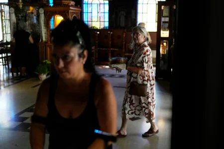 Maria Chanioti, 66, carries Fanouropita, an orange-flavored cake, to be blessed by a priest at the Church of St. Fanourios in Athens, Wednesday, Aug. 26, 2026. (Credit: Thanassis Stavrakis/AP.)