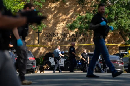 Law enforcement officers search the nearby neighborhood to clear the area after a shooting at Annunciation Catholic Church in Minneapolis, Aug. 27, 2025. (Credit: Alex Kormann/Star Tribune via AP.)