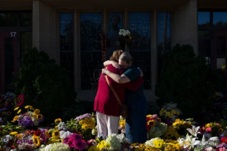 Women embrace at the memorial outside the Annunciation Catholic Church following a shooting at the school, Aug. 31, 2025, in Minneapolis. (Credit: Ellen Schmidt/AP.)