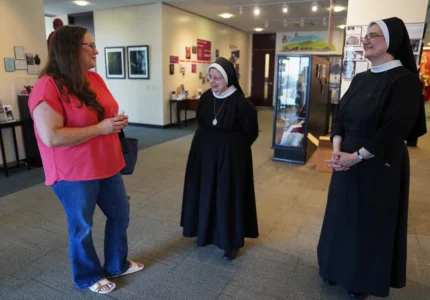 Bonnie Engstrom talks with two sisters at the Archbishop Fulton Sheen Museum in Peoria, Ill., on July 16, 2026. (Credit: Jessie Wardarski/AP.)